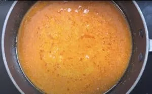 Rich, golden curry sauce simmering in a black pot, perfect for hearty meals and flavorful dishes.